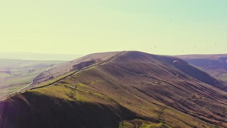 Aerial-Sunset-View-Of-Mam-Tor,-Peak-District-With-Paragliders-Soaring