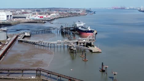 Crude-oil-tanker-ship-loading-at-refinery-harbour-terminal-aerial-view-zoom-out