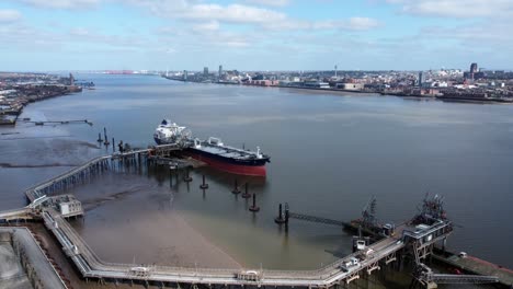International-crude-oil-tanker-ship-loading-at-refinery-harbour-terminal-aerial-view-push-in