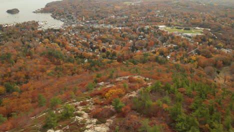 Drone-pan-up-from-the-top-of-mount-Battie-to-Camden,-Maine-during-autumn