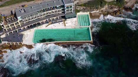 Aerial-View-Of-Sea-Water-Swimming-Pool-Alongside-Icebergs-Restaurant-Near-Bondi-Beach,-Sydney,-NSW,-Australia---drone-ascending