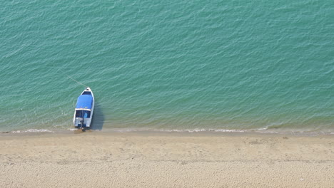 Kleines-Touristisches-Boot,-Das-Im-Meer-Nahe-Der-Draufsicht-Des-Weißen-Sandstrandes-Schwimmt