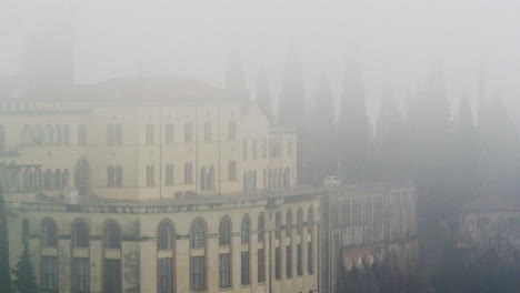 Toma-Panorámica-Izquierda-De-Un-Edificio-En-Verona-Durante-Una-Espesa-Niebla