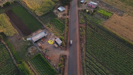 drone-following-Inova-car-from-top-in-rural-village-farm-road-cinematic-in-sunset-sunrise