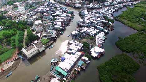 4K-Aerial-Drone-View-of-poor-dense-traditional-fishing-village-houses-on-stilts-built-on-a-river-canal-in-Hong-Kong,-Tai-O-Lantau-Island