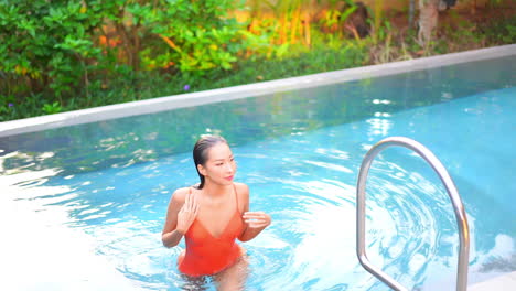 Sexy-slim-asian-woman-in-swimsuit-going-out-from-pool-water-fashion-and-tropical-holiday-concept,-full-frame-slow-motion