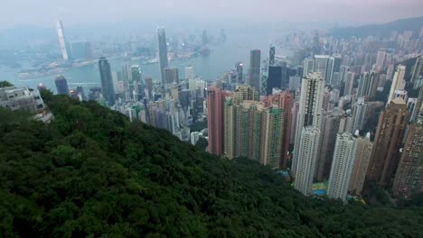 Aerial-4K-drone-cityscape-view-over-Hong-Kong-city-skyscrapers-skyline,-on-a-dark-gloomy-polluted-evening
