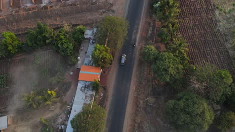 drone-following-Inova-car-from-top-in-rural-village-farm-road-cinematic-in-sunset-sunrise-Maharashtra-India-osmanabad