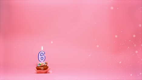 Happy-birthday-celebration-cupcake-with-frosting,-sprinkles-and-a-lit-up-6-years-old-candle-flame-burning-and-moving-around-on-a-pink-coral-background---seamless-boomerang-loop