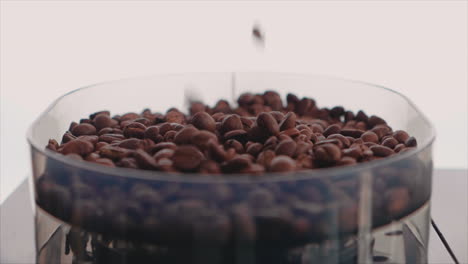 Braun-Geröstete-Kaffeebohnen,-Die-Zum-Mahlen-In-Den-Behälter-Fallen