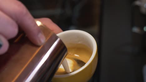Barista's-Hands-Pouring-Milk-Into-Cup-Of-Coffee