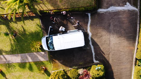 Aerial-view-above-people-coming-out-from-a-parked-van---screwdriver,-drone-shot