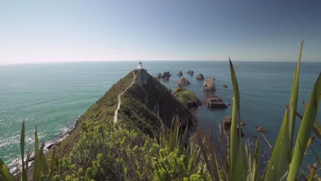 Vista-Panorámica-Del-Faro-Y-Las-Islas-Rocosas-En-El-Océano-Durante-El-Verano-En-Nueva-Zelanda