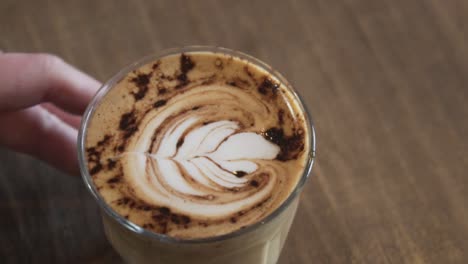 Barista-Serviert-Ein-Glas-Frisch-Gebrühten-Kaffee-Mit-Latte-Art-Und-Zimt