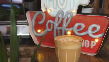 Vintage-Signage-Of-A-Coffee-Shop-With-Warm-Glass-Of-Cafe-Latte---close-up-shot