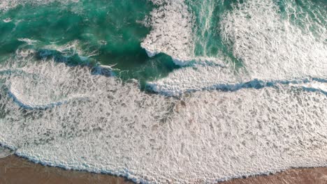 Drone-view-of-beautiful-seamless-never-ending-footage-while-turquiose-sea-waves-breaking-on-sandy-coastline