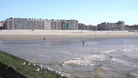 Gebäude,-Meerpromenade-Mit-Touristen-In-Der-Küstenstadt-Nieuwpoort,-Belgien-Tagsüber---Statische-Aufnahme