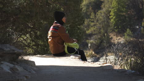 Female-Tourist-Resting-On-Pathway-Edge-At-Walnut-Canyon