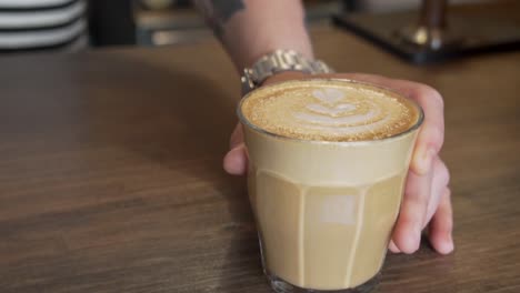Männliche-Hand,-Die-Ein-Glas-Latte-An-Der-Kaffeebartheke-Serviert
