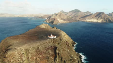 Entfernter-Leuchtturm-Auf-Steiler-Klippe-Der-Felsigen-Insel-Mit-Porto-Santo-Im-Hintergrund