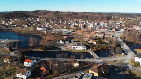 Aerial-pan-shot-of-small-swedish-village-named-Bengtsfors-with-lake-and-hills-in-background-during-beautiful-weather-outdoors