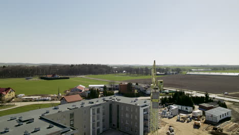 Sectional-Panel-Building-construction-site-with-crane-working-on-spot-in-Lubawa-Poland-daytime---drone-slow-descending-motion-over-the-building