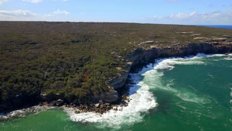 Waves-Crash-Through-Sandstone-Coastal-Cliffs-With-Lush-Vegetation-At-Royal-National-Park-In-Sydney,-New-South-Wales,-Australia