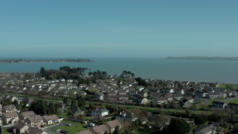Aerial-drone-shot-of-village-by-the-sea-coast-at-day,-wide-angle