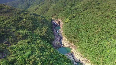 Sai-Kung-famous-rock-pools-and-waterfall-as-seen-from-bird's-eye-view,-forward-aerial-shot-tilting-down