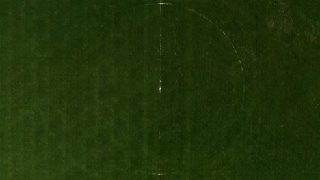 Aerial-top-down-ascending-view-of-football-field-at-day