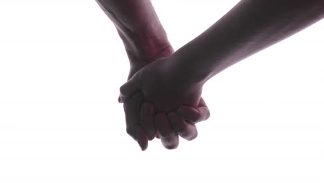 Couple-Holds-Hands---A-Man-And-A-Woman-Holding-Hands-With-Their-Fingers-Interlocked---close-up,-studio-shot