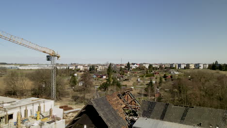Grúa-En-El-Sitio-De-Construcción-Junto-A-Las-Ruinas-De-Una-Casa-Abandonada-En-Lubawa,-Polonia
