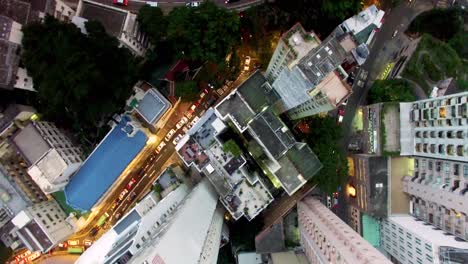 Aerial-4K-drone-top-down-bird's-eye-view-over-Hong-Kong-dense-city-skyscrapers-and-busy-streets,-in-the-evening