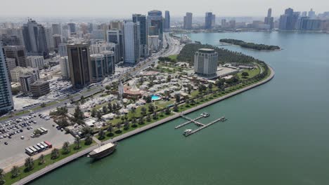 Sharjah:-Aerial-view-of-Sharjah-city-and-Khalid-lake,-Al-Noor-Mosque,-modern-skyscrapers-in-the-United-Arab-Emirates