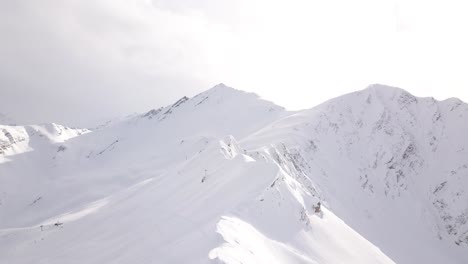 Luftdrohnenansicht-Eines-Schneebedeckten-Berggipfels-Und-Einer-Gebirgskette-Im-Winter