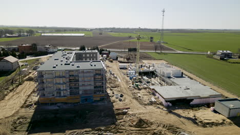 Work-in-progress-on-building-construction-site-in-Lubawa-Poland,-aerial-side-movement