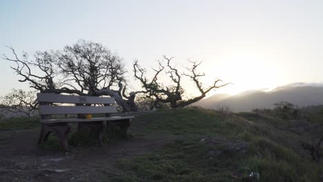 Soft-Pedestal-Shot-of-Lonely-Bench-on-the-Peak-of-Some-Green-Hills-of-California-on-a-Somber-Morning