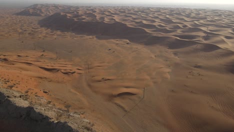 UAE:-Aerial-view-tourist-riding-on-horses-walking-in-the-desert-of-Mleiha,-Sharjah-Desert,-United-Arab-Emirates