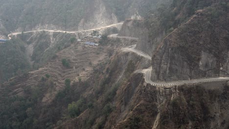 A-winding-road-in-the-mountains-of-Nepal-with-a-steep-cliff-on-the-side-as-seen-from-a-high-angle