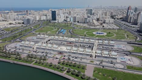 Drone-view-of-Sharjah-central-souq,-Gold-souq-and-city-skyline-on-a-bright-summer-day,-United-Arab-Emirates