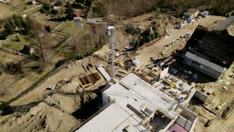 top-down-aerial-near-building-crane-over-empty-construction-site