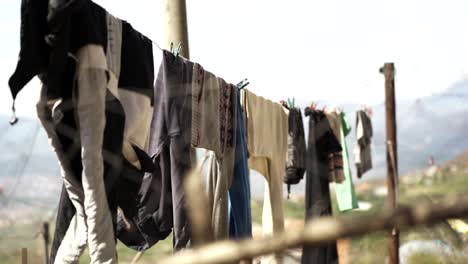 Clean-washed-clothes-hanged-on-wire,-blurred-nature-background-in-village