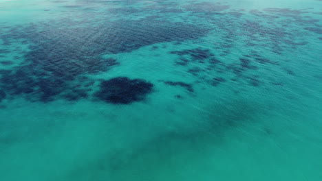 Aerial-view-shallow,-turquoise-water,-in-New-Caledonia---low,-dolly,-drone-shot