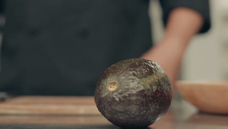 Unrecognizable-man-grabs-avocado-with-hand