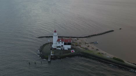 Early-morning-at-popular-Dutch-Lighthouse-Paard-van-Marken-at-lake,-aerial