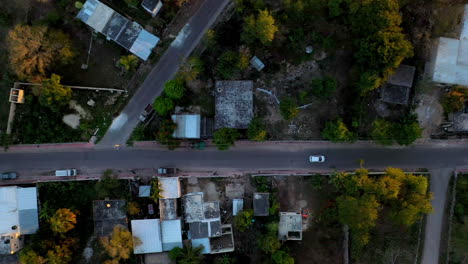 Drone-shot-downward-angle-of-white-car-driving-through-the-city-of-Merida-Mexico