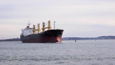 Very-large-Tanker-making-a-turn-across-harbor,-static-tripod-establishing
