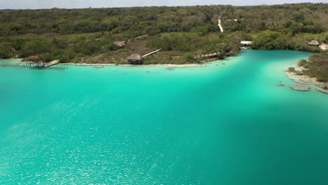 Rotating-drone-shot-of-clear-blue-water-and-coastline-at-Bacalar-Mexico