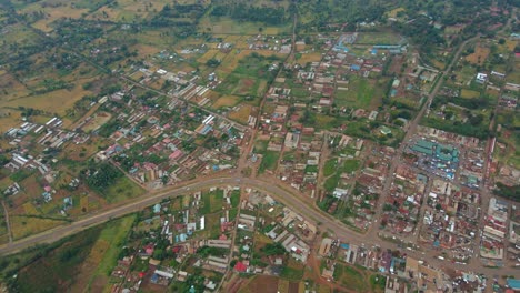 Aerial-view-overlooking-a-village-center,-on-countryside-of-Kenya---high-angle,drone-shot
