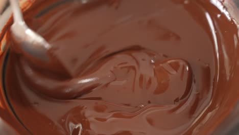 Mezclando-Chocolate-Derretido-En-Un-Recipiente-De-Acero-Con-Una-Cuchara,-Cierre-A-Cámara-Lenta